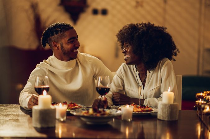 African american couple having romantic date and drinking wine at home